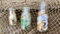 Sea glass shells and fragments on fishing net background in bottle