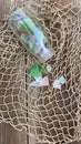 Sea glass vertical on  fishing net background in bottle Royalty Free Stock Photo