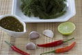 Sea grapes or green caviar and spicy sauce on a white dish the wooden dish made of Japanese style bamboo Royalty Free Stock Photo