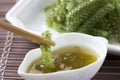 Sea grapes or green caviar and spicy sauce on a white dish the wooden dish made of Japanese style bamboo Royalty Free Stock Photo