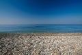 Sea gravel shore or beach and deep blue sky