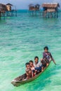 Sea Gypsy Kids on their sampan with their house on stilts in the