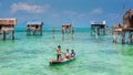 Sea Gypsy Kids on their sampan with their house on stilts in the