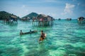 Sea Gypsy Kids on their sampan with their house on stilts in the