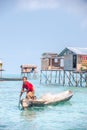 Sea Gypsy Woman paddling her sampan with her kids.