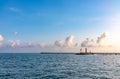 Sea harbor with breakwater and lighthouse at sunset Royalty Free Stock Photo