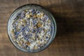 Sea himalayan salt with dry lavender and chamomile flowers in a glass jar on wooden background, closeup, top view Royalty Free Stock Photo
