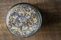 Sea himalayan salt with dry lavender and chamomile flowers in a glass jar on wooden background, closeup, top view Royalty Free Stock Photo