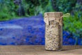 Sea himalayan salt with dry lavender and chamomile flowers in a glass jar on wooden table with the blue flowers background on a Royalty Free Stock Photo