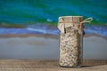 Sea himalayan salt with dry lavender and chamomile flowers in a glass jar on wooden table with the blue sea water background on a Royalty Free Stock Photo