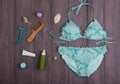 Sea holidays / travel concept - blue beautiful swimsuit and accessories: wooden hairbrush, sunscreen, bottles with cream, razor
