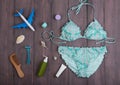 Sea holidays / travel concept - blue beautiful swimsuit, airplane and accessories: wooden hairbrush, sunscreen, bottles with cream Royalty Free Stock Photo