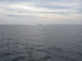 Sea and horizon with container ship in distance a