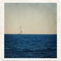 Sea landscape of the Baltic Sea with a white sail on the water in the style of an old postcard with a frame Royalty Free Stock Photo