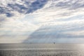 Sea landscape with a beautiful view of the clouds and beams of sun which are making way through a cloud Royalty Free Stock Photo