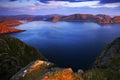 Sea landscape in the Norway. Evenig pink light on the ocean coast. Rocky cost in the summer night. Water surface with beautiful li