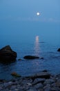 Sea landscape at sunset with moon, stone coast and beautiful sky Royalty Free Stock Photo