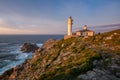 Sea landscape view of Cape Tourinan Lighthouse at sunset with pink clouds, in Spain Royalty Free Stock Photo