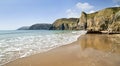 Sea meets sand reflecting the towering Pembroke Coastline between Lydstep and Manorbier Bay Royalty Free Stock Photo