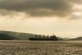Sea merchant ship is on the raid on the background of the hills of Vladivostok in the dawn rays of the sun