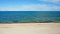 Sea. ocean. sea surface. almost calm. deserted beach. horizon line. dark blue water, clean sandy beach and light clouds in the sky Royalty Free Stock Photo