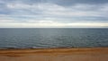 sea. ocean. sea surface. almost calm. horizon line. dark blue water  sandy beach and cloudy sky Royalty Free Stock Photo