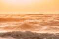 Sea ocean water surface with foaming small waves at sunset. Evening sunlight sunshine above sea. Beautiful natural Royalty Free Stock Photo