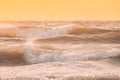 Sea ocean water surface with foaming small waves at sunset. Evening sunlight sunshine above sea. Natural sunset sky warm Royalty Free Stock Photo