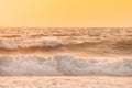 Sea ocean water surface with white foaming small waves at sunset. Evening sunlight sunshine above sea. Natural sunset Royalty Free Stock Photo
