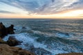 sea or ocean wavy water with stony shore and cloudy sunset sky, nature beauty