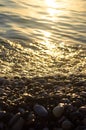 Sea pebble beach with multicoloured stones, waves with foam Royalty Free Stock Photo