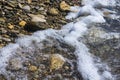 sea pebble beach with multicoloured stones, waves with foam Royalty Free Stock Photo