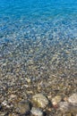 sea pebble beach with multicoloured stones, waves with foam Royalty Free Stock Photo