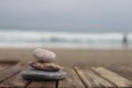 Sea pebbles pyramide of sea stones on a wet sun lounger against the background of the sea, rainy evening, storm at sea. Royalty Free Stock Photo