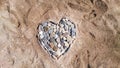Sea pebbles in the shape of a heart on a sandy beach. Romantic holiday concept or symbol of love Royalty Free Stock Photo