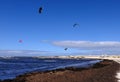 Sea with people parachuting over it in the bright skyline