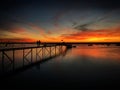 Sea pier with a couple during sunset near Faro, Portugal, December 2018 Royalty Free Stock Photo