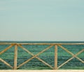 Sea pier with an old wooden fence against the background of the horizon. Royalty Free Stock Photo