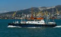 Sea Pilot `Adis` is sailing in blue water Black Sea. White work boat `Adis` on Novorossiysk Commercial Sea Port and mountains