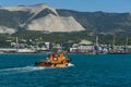 Sea Pilot `Lotsman-1` is sailing in turquoise water along Tsemes bay. Close-up of orange boat `Pilot-1` on Novorossiysk