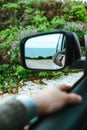 sea reflection in car rear mirror. road trip