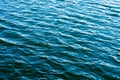 Sea ripples. Bright background. Dark green water. Shallow waves and sun glare on the water. Royalty Free Stock Photo