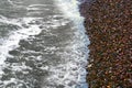 Sea rolling and receding water in rays of setting sun. Royalty Free Stock Photo