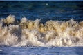 Sea rolling and receding water in rays of setting sun. Royalty Free Stock Photo