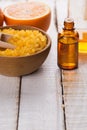 Sea salt in bowl, aroma oil on wooden background