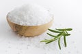 Sea salt bowl and fresh rosemary twig on white table