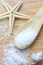 Sea salt crystals in wooden spoon on wooden background