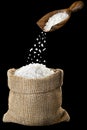 sea salt falling from wooden scoop in burlap bag Royalty Free Stock Photo