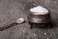 Sea salt in an old utensils and a small spoon on a wooden table Royalty Free Stock Photo