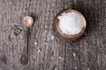 Sea salt in an old utensils and a small spoon on a wooden table Royalty Free Stock Photo